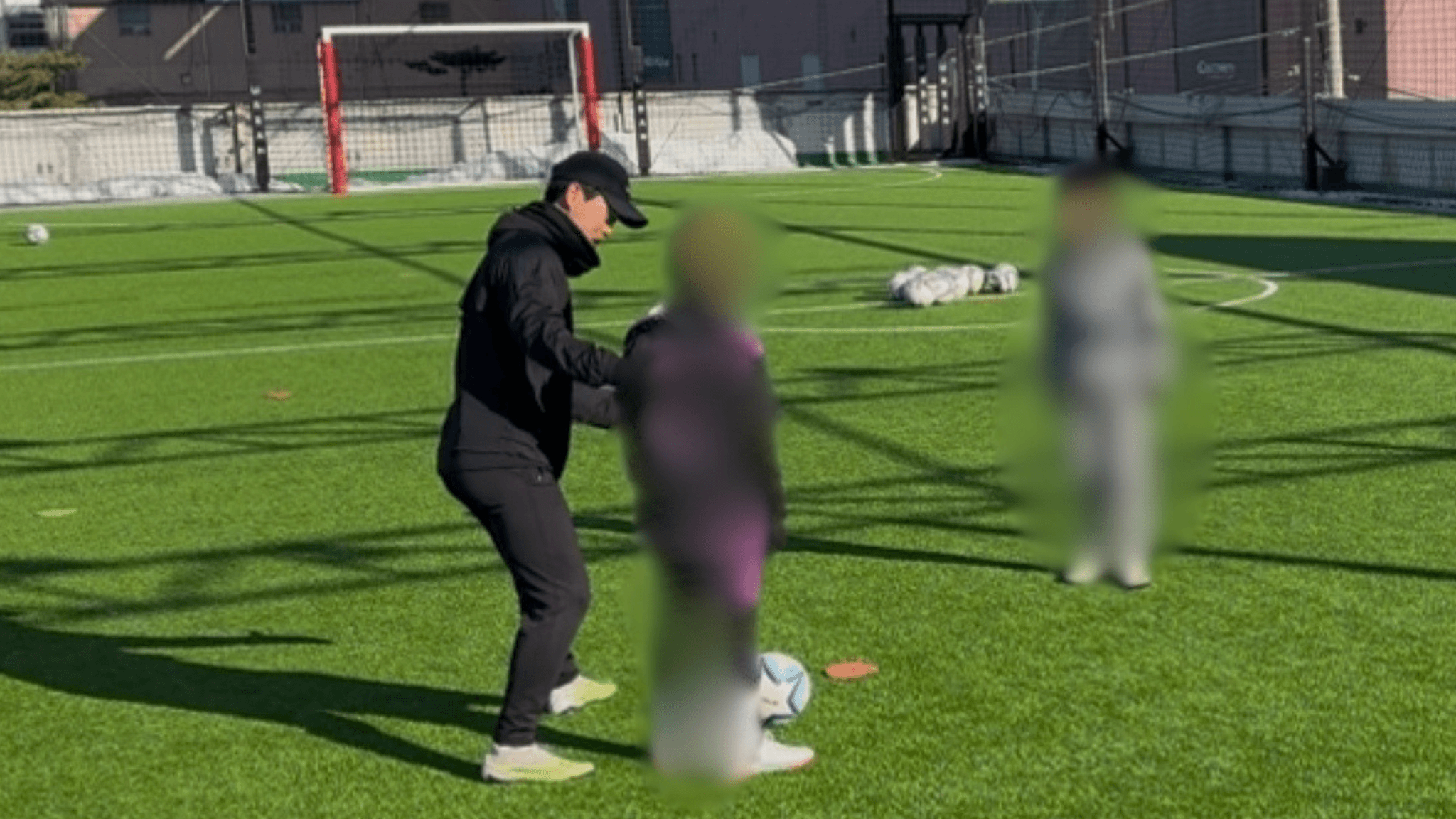 더필드 코치가 축구장에서 선수에게 경기 상황을 지도하는 모습